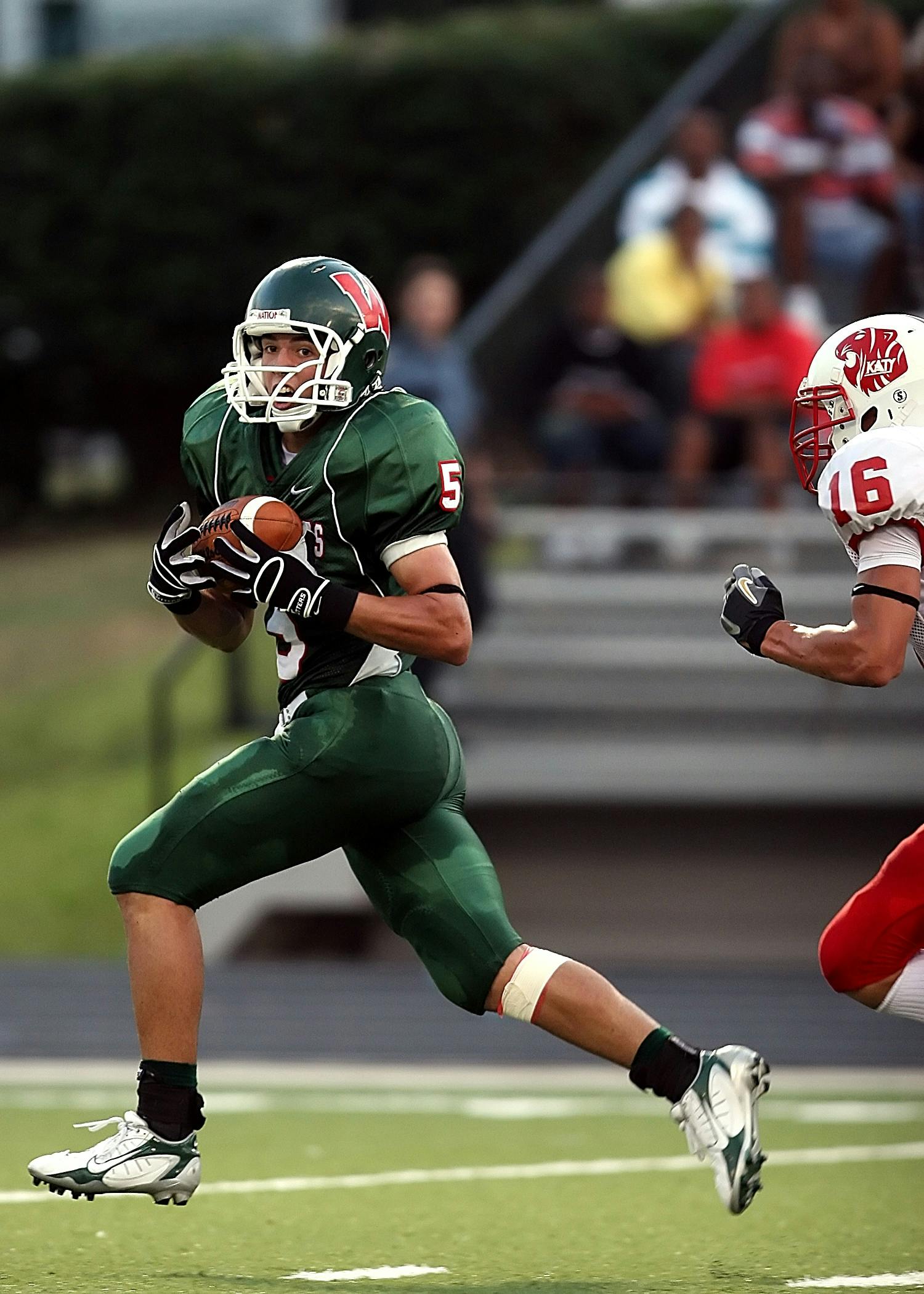 Dynamic scene of football players in motion during a competitive game on the field.