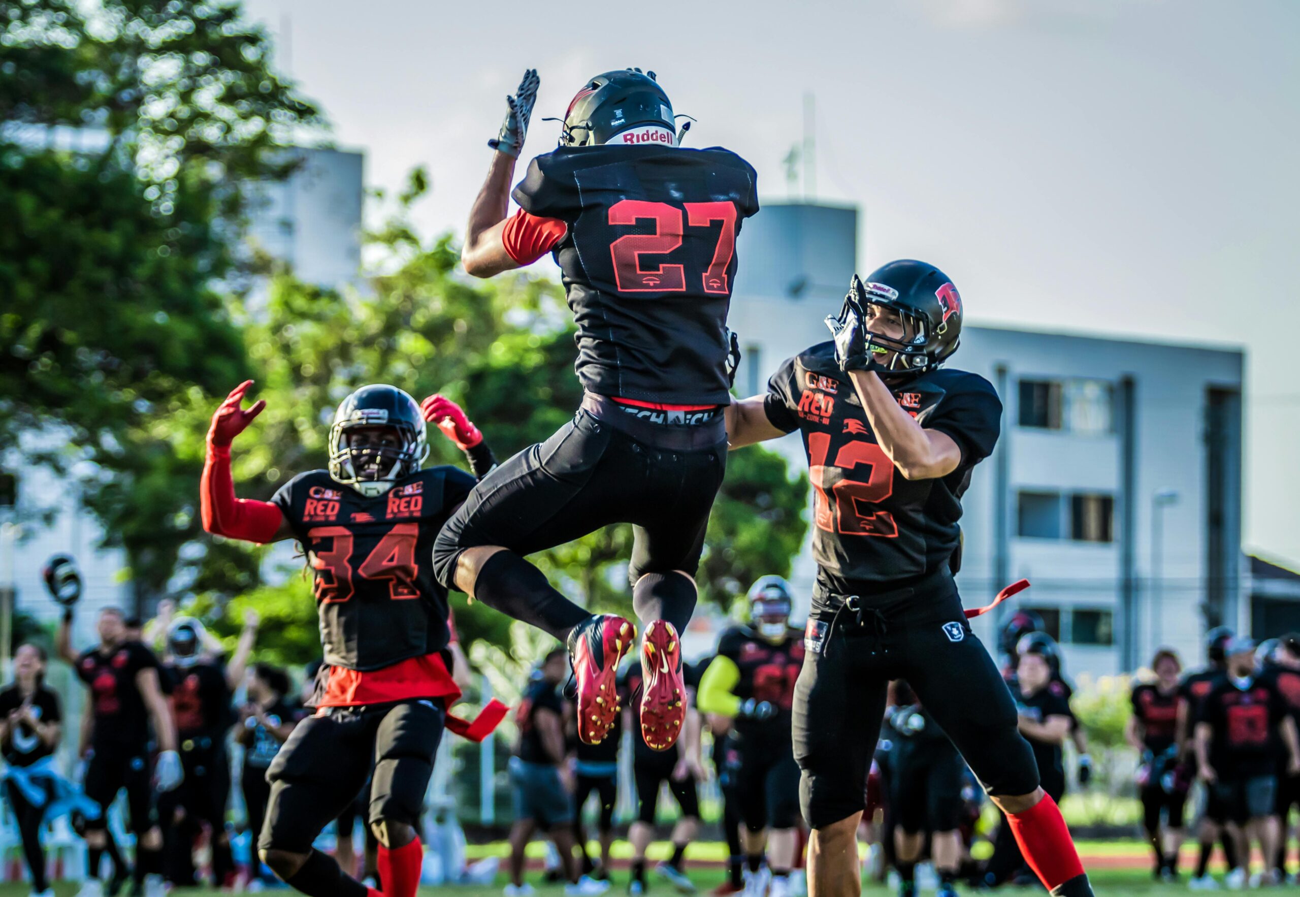 Energetic capture of players in mid-air during an American football game outdoors.